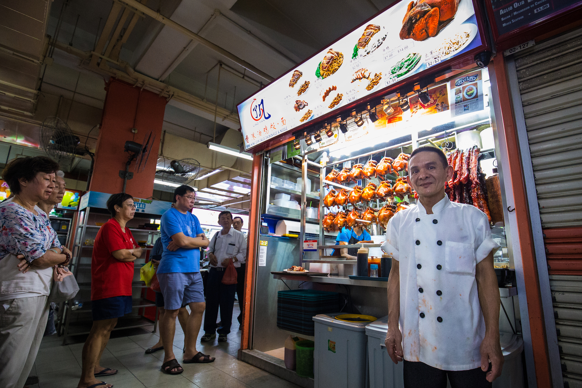 Chan Hong Meng poses for a photo at his Hong Kong Chicken Rice and Noodle stall at Chinatown Complex on July 24, 2016 in Singapore. Chan was awarded a one-star rating by Michelin on July 21, making him one of the first street food hawkers to be awarded in the guide's history.