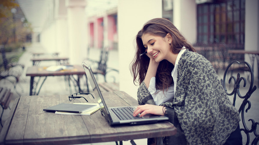 smiling-young-woman-with-laptop-outdoors